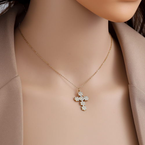 Goudkleurige Bloom Cross ketting met bloemenkruis van glinsterende zirkonia steentjes om de hals gedragen van roestvrij staal