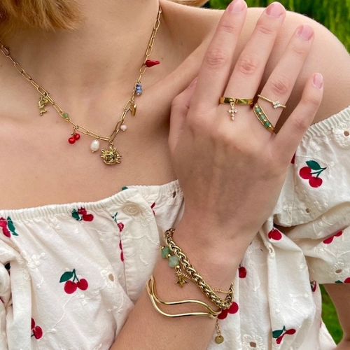 Goudkleurige verstelbare stainless steel ring met groene kralen gecombineerd met andere sieraden