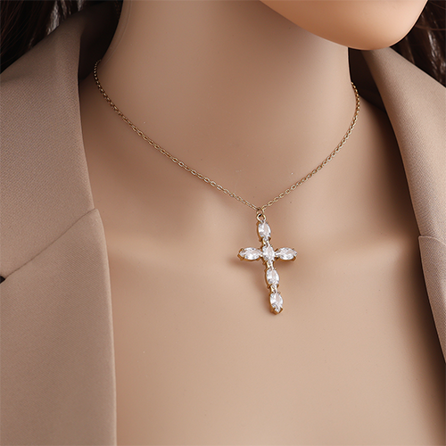 Goudkleurige ketting met kruis hanger ingelegd met zirkonia steentjes om de hals gedragen - van roestvrijstaal